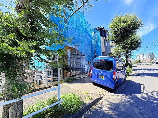 青い外壁の建物と前面道路