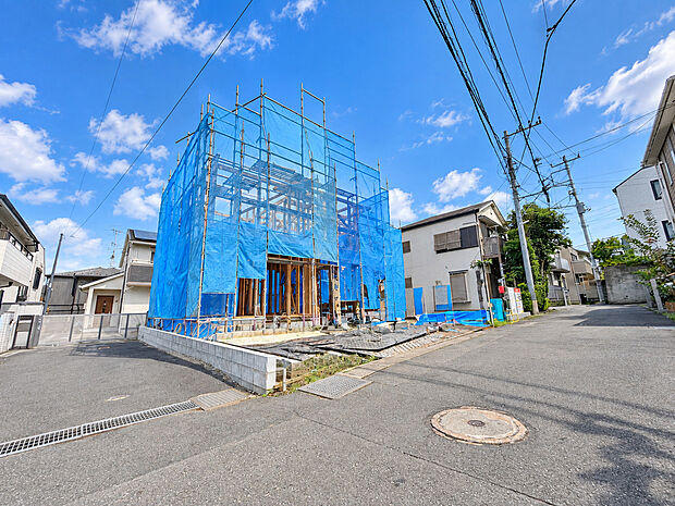 青いネットで覆われた建築中の建物と周辺道路