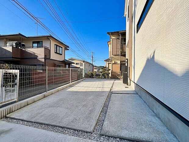 建物脇の舗装された通路と周辺住宅