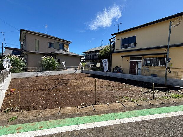 道路沿いの敷地と戸建て外観