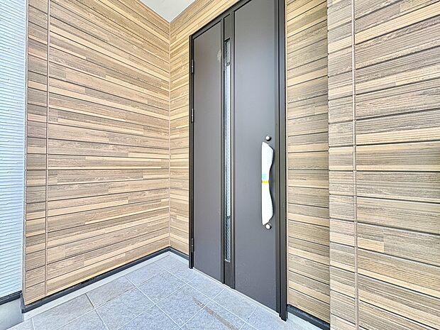 木目調の壁に囲まれた玄関前のアプローチ