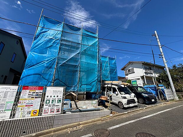 青いシートで覆われた建物と前面道路