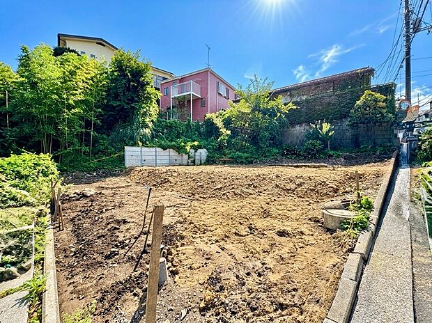 道路沿いの更地と周囲の住宅