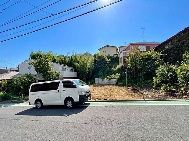 前面道路と植栽のある住宅外観