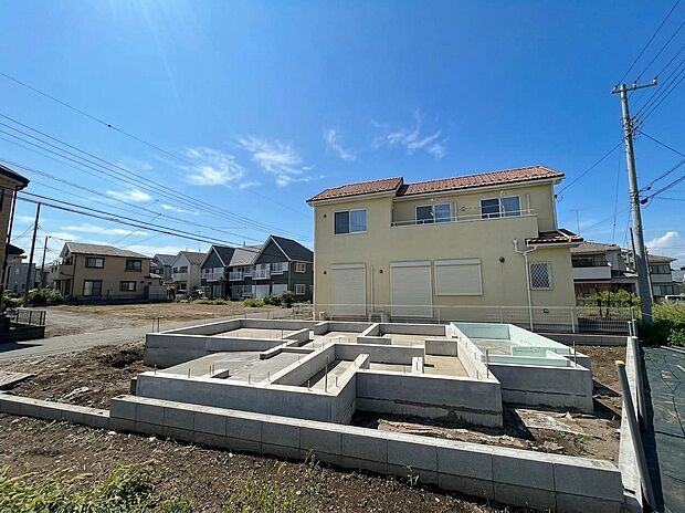 建築中の戸建て住宅と基礎、周辺に住宅が見える