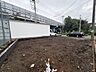 外観：建物脇の整地された敷地と前面道路