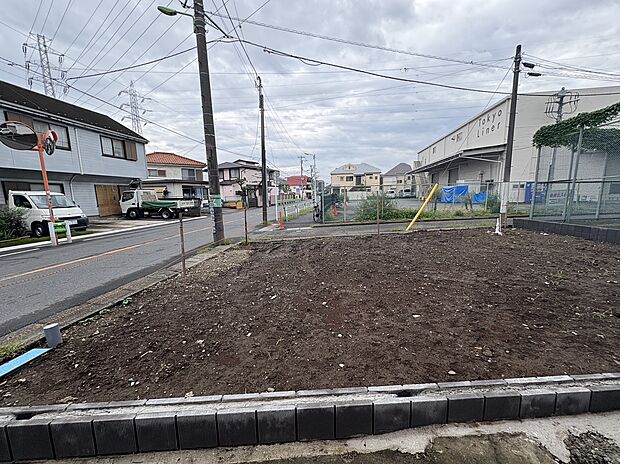 道路沿いの整地された土地周辺に住宅や建物あり