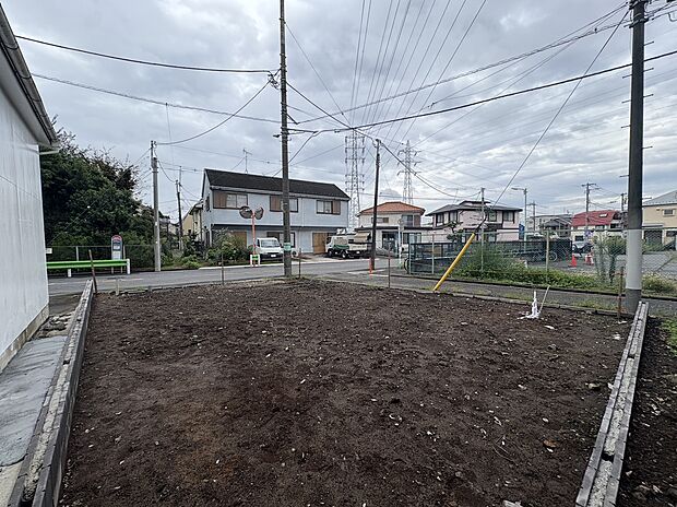 建物周囲の更地と前面道路