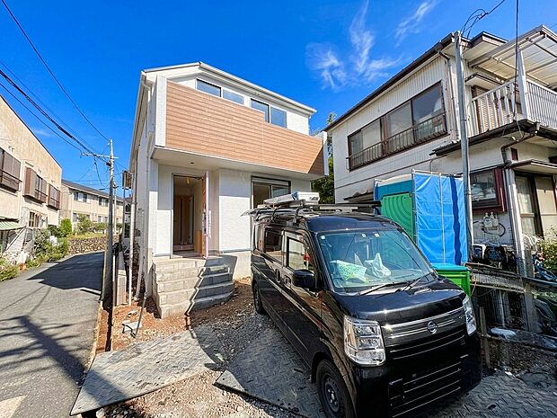 住宅外観と前面道路、駐車スペースの様子