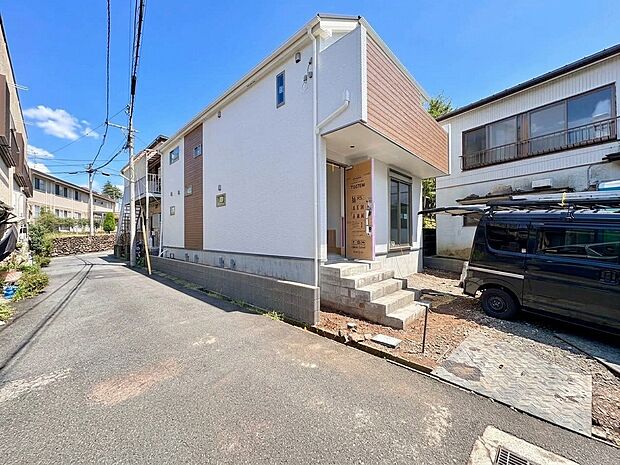 道路に面した白い外観の住宅と駐車スペース