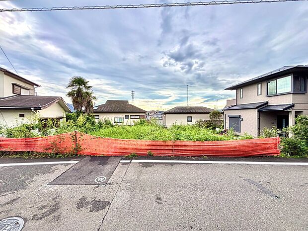 道路沿いの建物外観と前面の空き地