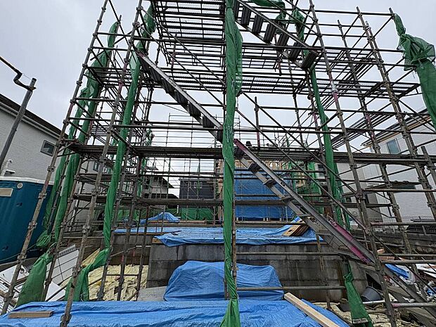 建築中の建物を覆う足場と養生シート