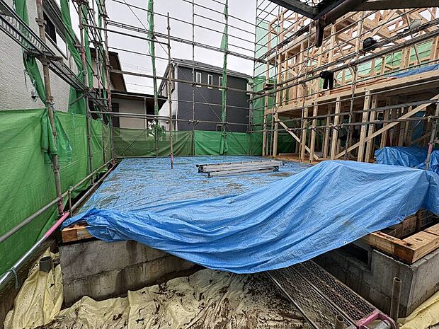 建築中の建物と青い養生シート
