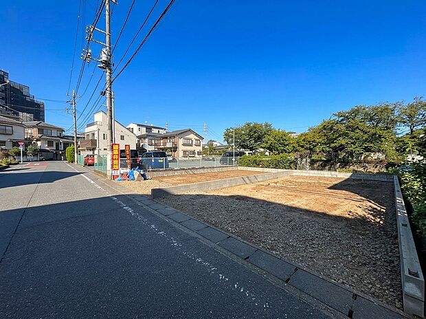 前面道路と周辺の住宅、空き地が見える外観周辺