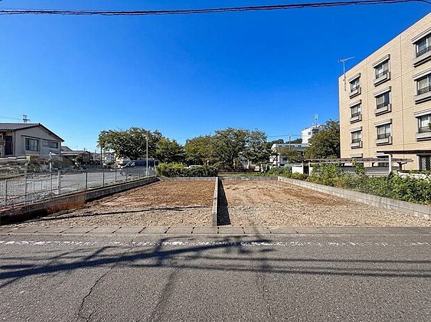 道路沿いの更地と周辺の建物