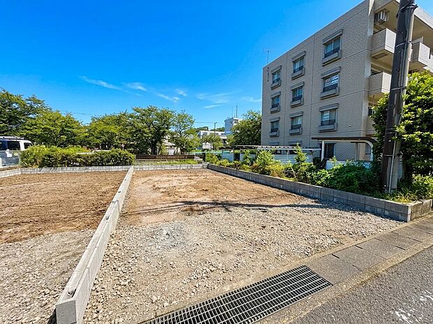建築前の区画された更地周辺に住宅や建物が見える