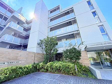 植栽と砂利敷きの前庭がある集合住宅の外観