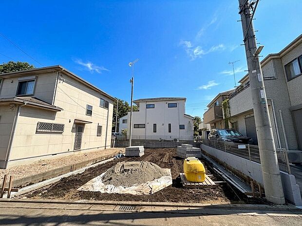 住宅に囲まれた建築中の区画と前面道路