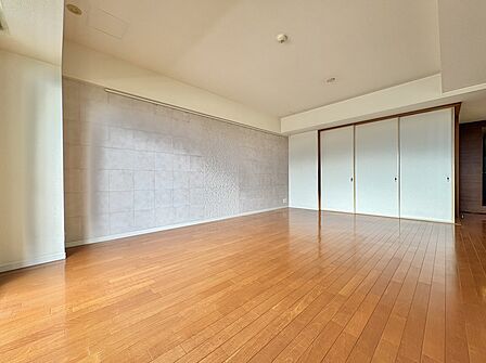 大きな窓と鏡張りの壁があるフローリングの洋室