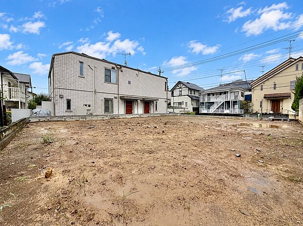 建物に囲まれた整地前の広い敷地