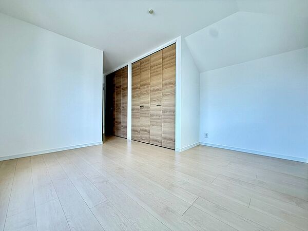 木目調の床と建具がある明るい洋室