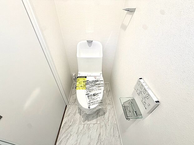 白を基調としたトイレ壁面に収納棚あり