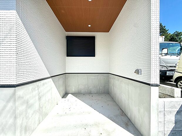 白い外壁の建物に面したコンクリート敷地