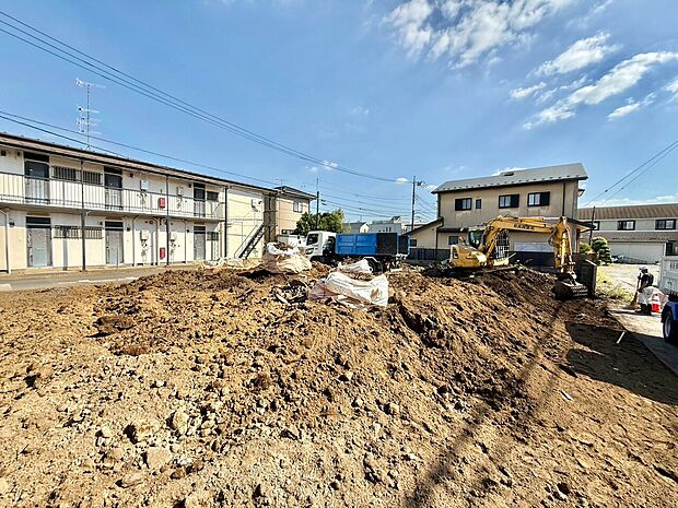 建築中の戸建て住宅と整地中の敷地