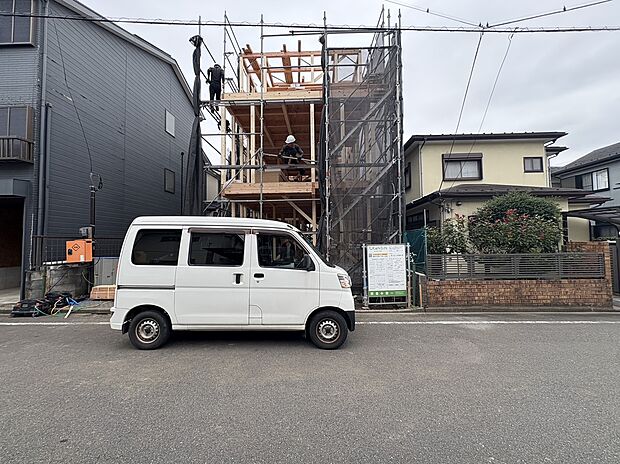 前面道路から見た建物外観と駐車車両