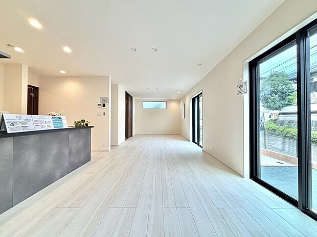 明るく開放的な室内大きな窓とキッチンが見える