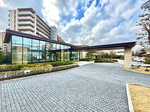 建物と植栽、石畳のアプローチが見える外観