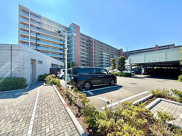 集合住宅と敷地内の歩道・植栽、駐車場を望む外観