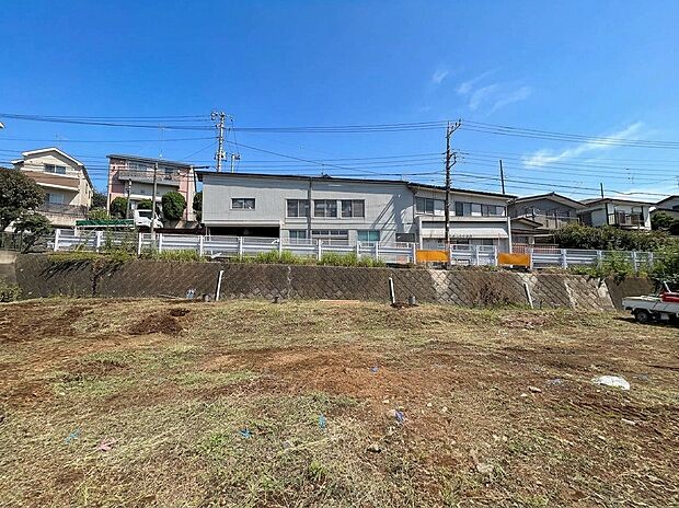 建物を望む広い更地と周辺住宅