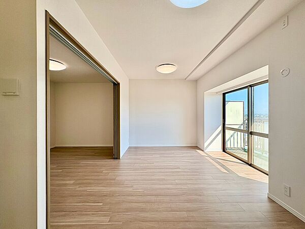 窓から光が入る木目調の広い居室