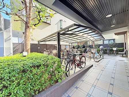 屋根付きの通路と植栽、自転車置き場