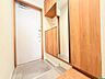 玄関：木目調の収納を備えた玄関スペース