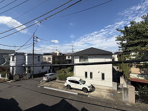 建物外観と前面道路、周辺の住宅を望む景観