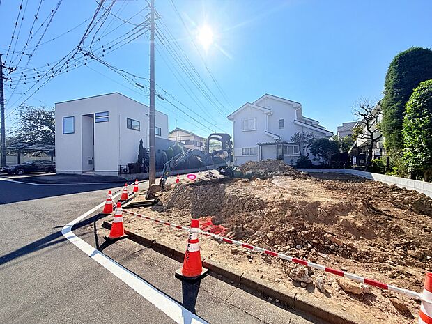 道路沿いの造成中の敷地と周辺住宅