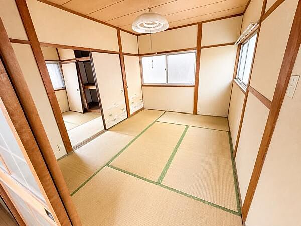 和室ならではの落ち着いた雰囲気が広がります。複数の窓があり自然光が室内を明るく照らします。畳の風合いが感じられる空間です。スライド式の扉が便利で隣室との行き来もスムーズです。