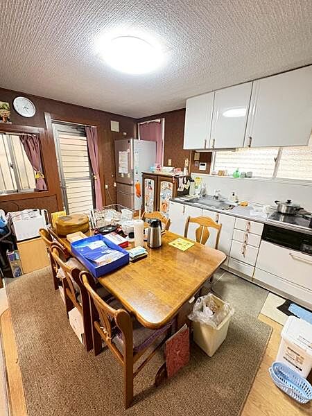 ダイニングテーブルと椅子がセットされ家事動線がスムーズなキッチン空間です。収納スペースが豊富で日々の片付けも簡単に行えます。明るい照明と窓からの自然光で室内が快適に保たれています。