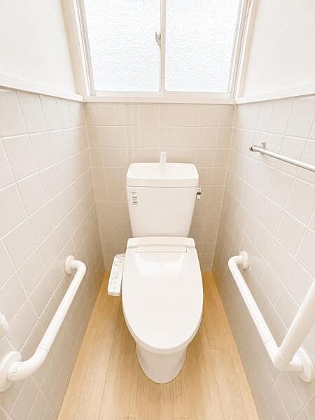 窓付きで換気がしやすいトイレです。手すりが両側に設置されており安心して利用できます。清潔感のあるタイル壁が特徴です。明るい雰囲気の空間になっています。CGにて合成しております。