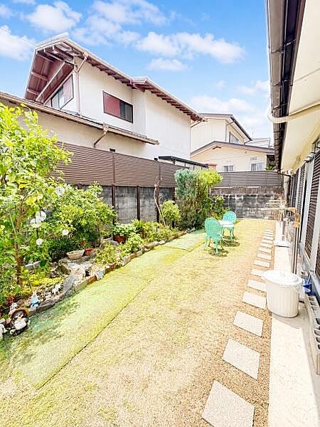 庭には植栽が配置されており緑が感じられる空間です。奥にはチェアが設置されており過ごしやすい印象です。歩きやすいように飛び石が並んでおり手入れがしやすそうです。広さを感じさせるレイアウトです。