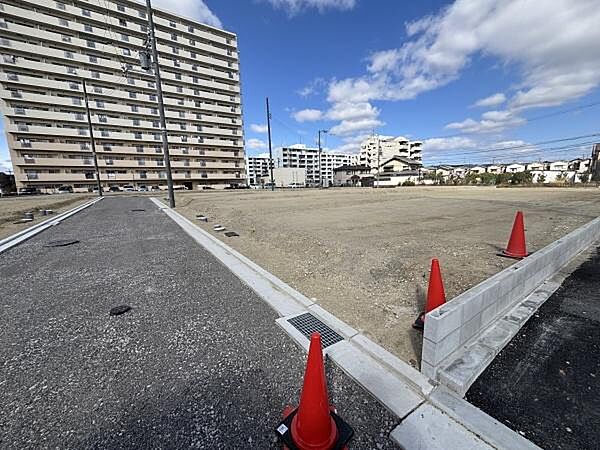 広々とした現地土地写真です。整地がされており建築プランも検討しやすいスペースです。周囲にはマンションや住宅が並んでおり生活利便性にも期待できる環境です。日当たりも良好です。