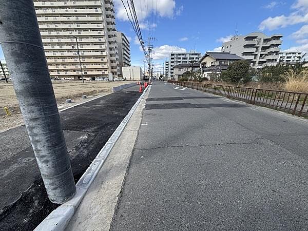 前面道路がしっかり整備されており車の出入りもスムーズに行えます。周辺には高層の建物が並び開放感のある印象です。通り沿いには電柱やフェンスが設置されていて安全面も配慮されています