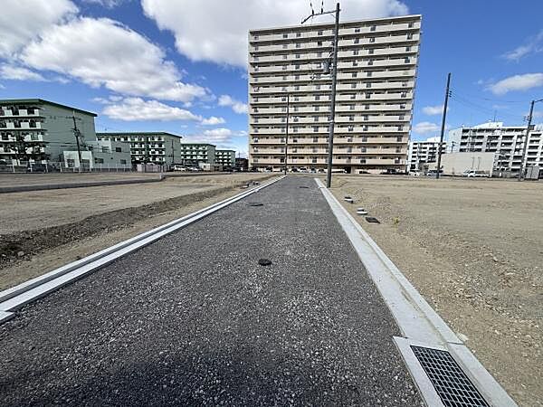 周辺には複数のマンションが立ち並び整備された道路が敷かれております。見通しの良い直線道路で区画整理も進んでいます。土地の平坦さが際立ち工事や建築にも適しています。周囲の建物とのバランスも良好です。