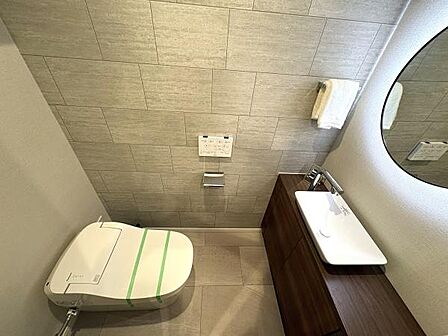 広々とした落ち着く雰囲気のトイレルーム。スタイリッシュなタンクレストイレ、丸い大きな鏡がおしゃれです。温水洗浄便座付！