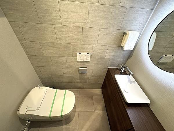 広々とした落ち着く雰囲気のトイレルーム。スタイリッシュなタンクレストイレ、丸い大きな鏡がおしゃれです。温水洗浄便座付！