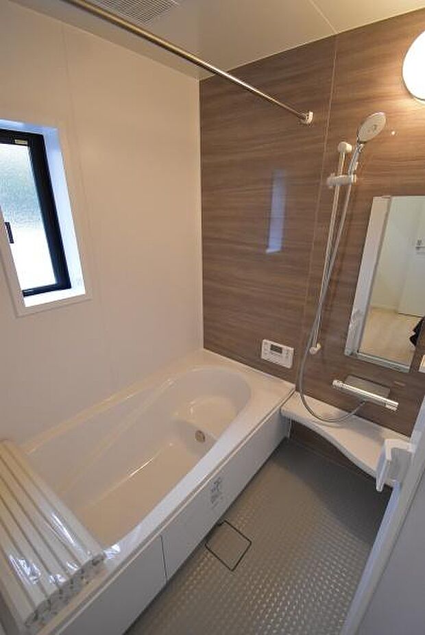 同社施工例写真 浴室乾燥機付きでお天気の悪い日のお洗濯ものも安心バリアフリー設計で安心のバスルーム。お子様も安心な浴槽内ステップ付。色・仕様は実際の物件と異なる場合がございます。