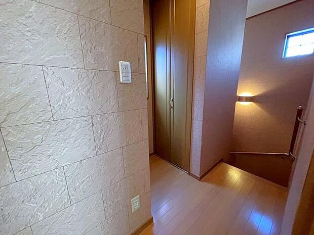 2階の廊下は階段と同じタイル風の壁紙が貼られており、窓からは程よい光と風が差し込んできます。便利な収納スペースもあります。