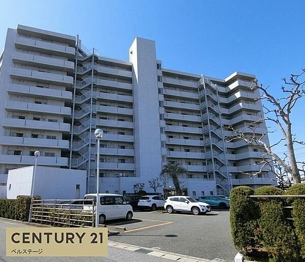 堂々としたフォルムが印象的な大規模マンションの外観。整然と並ぶデザインから落ち着いた住環境が感じられます。敷地内には駐車スペースも確保され、建物周辺の植栽もきれいに整えられています。